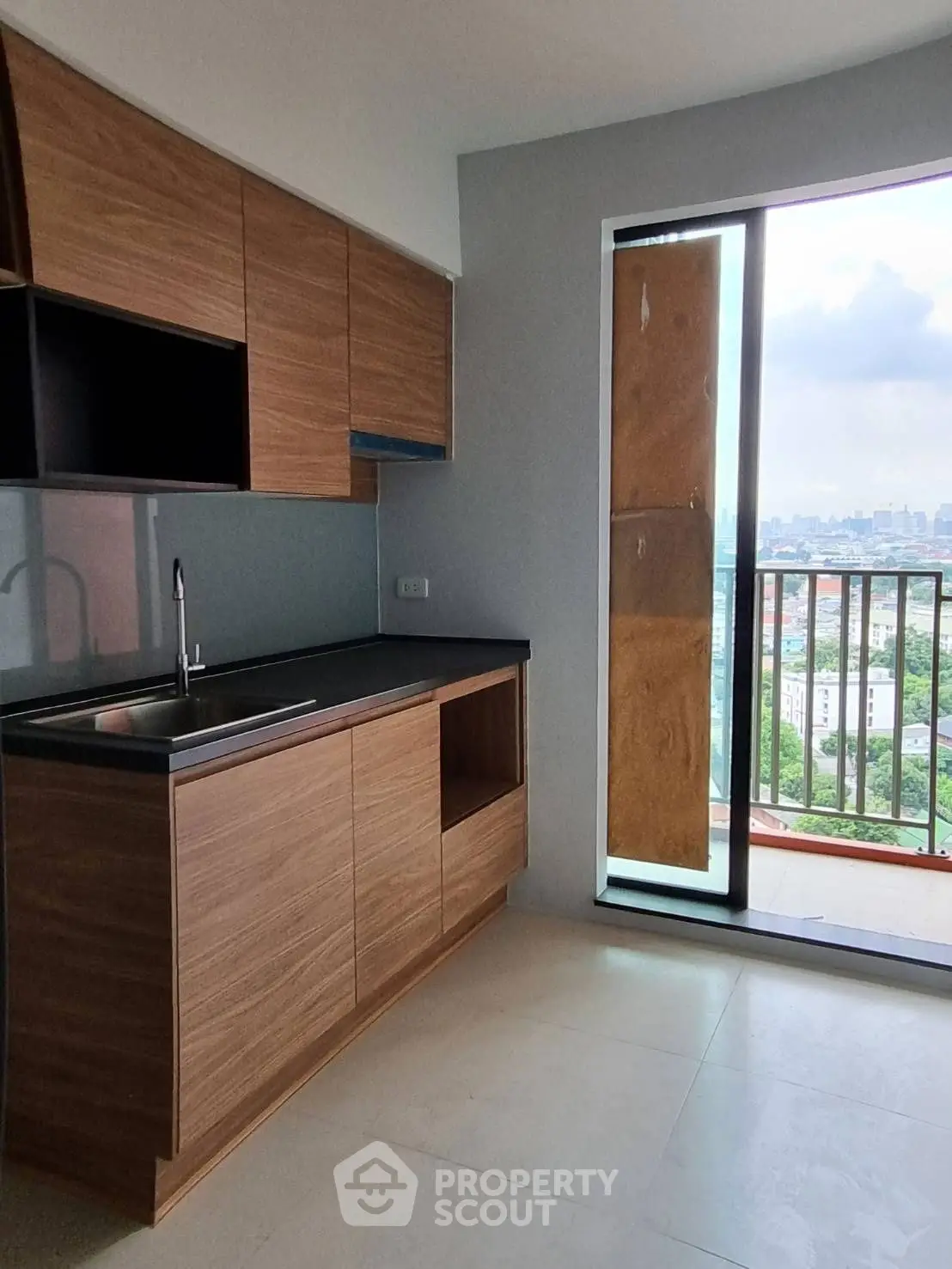 Modern kitchen with sleek cabinetry and balcony view in urban apartment