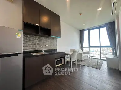 Modern open-layout kitchen and living room with large windows and city view.