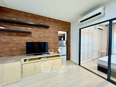 Modern living room with wood accent wall and sliding glass doors to bedroom