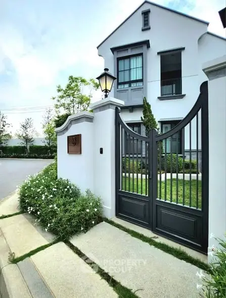 Elegant modern house exterior with stylish gate and lush greenery