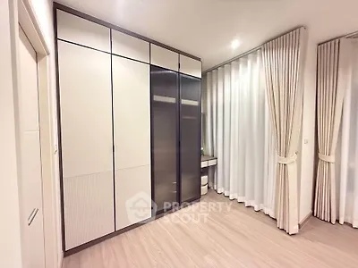 Spacious modern bedroom with elegant curtains and ample closet space