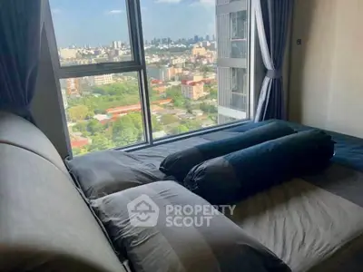 Spacious bedroom with panoramic city view from large window, offering a serene and modern living experience.