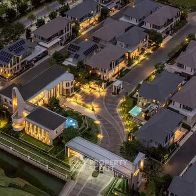 Luxurious gated community with modern homes and ambient lighting at dusk.