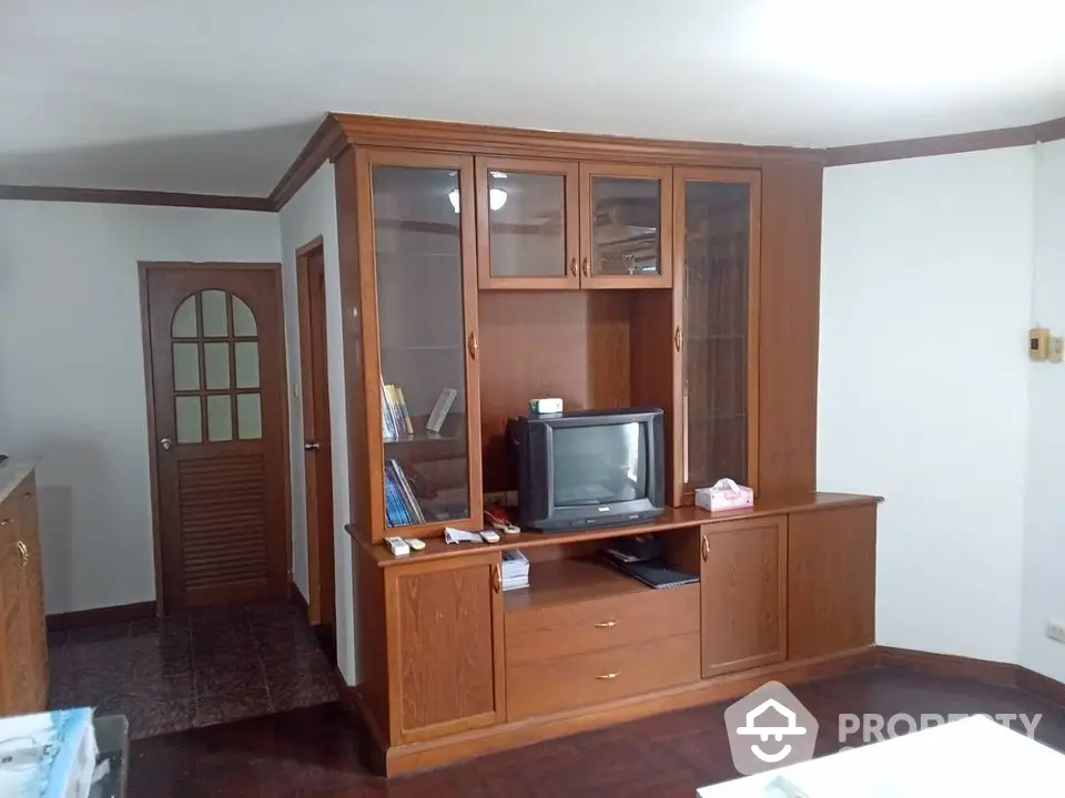 Cozy living room with vintage wooden entertainment center and classic TV