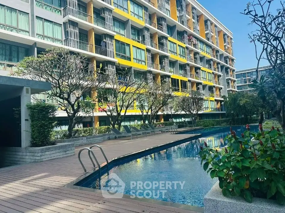 Modern apartment building with pool and lush garden view