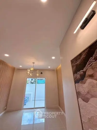 Modern interior with elegant lighting and large glass doors leading to a bright outdoor space.