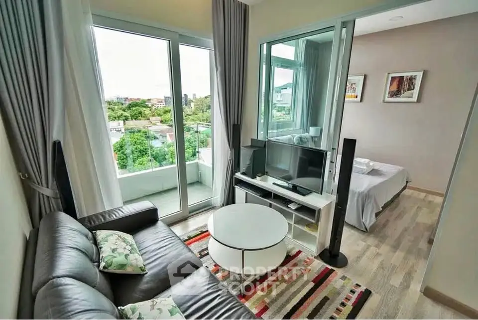 Modern living room with balcony view and cozy bedroom in open layout apartment