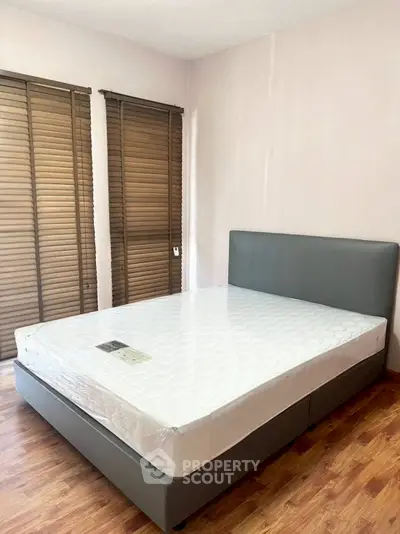 Spacious bedroom with modern bed and wooden flooring, perfect for comfort and style.