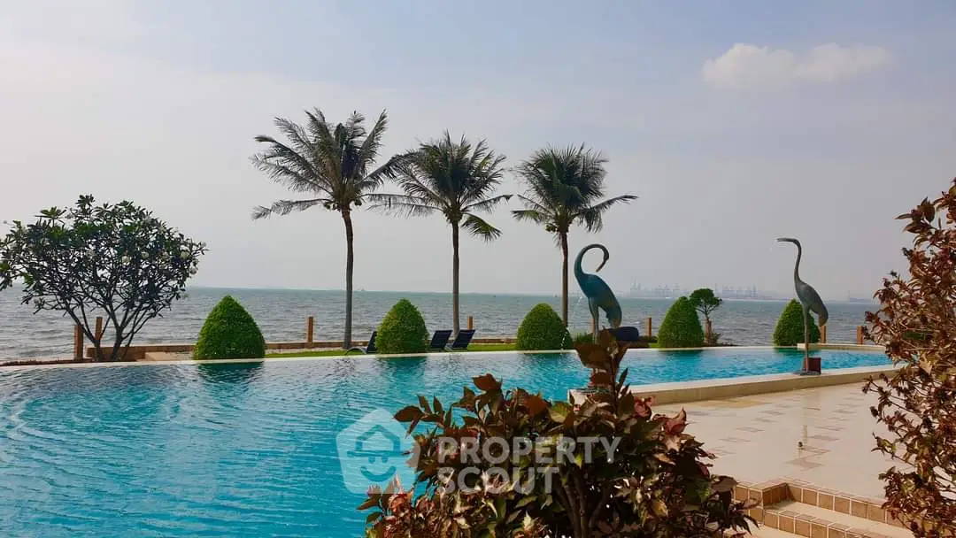 Luxurious beachfront pool with stunning ocean view and palm trees
