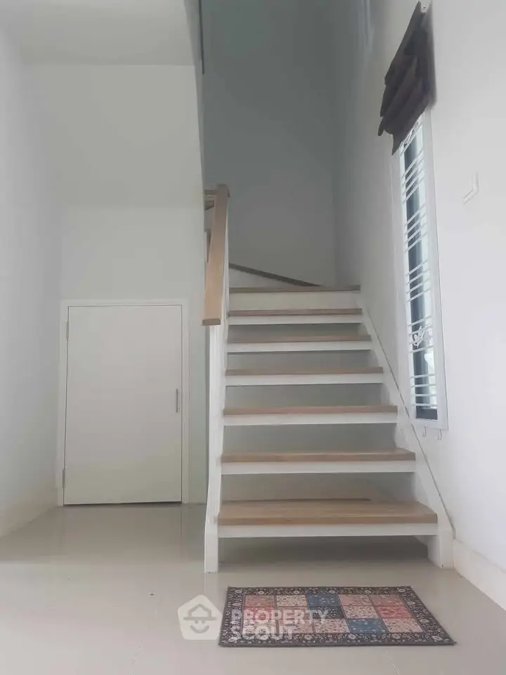Modern staircase with sleek design in a bright, minimalist home interior.