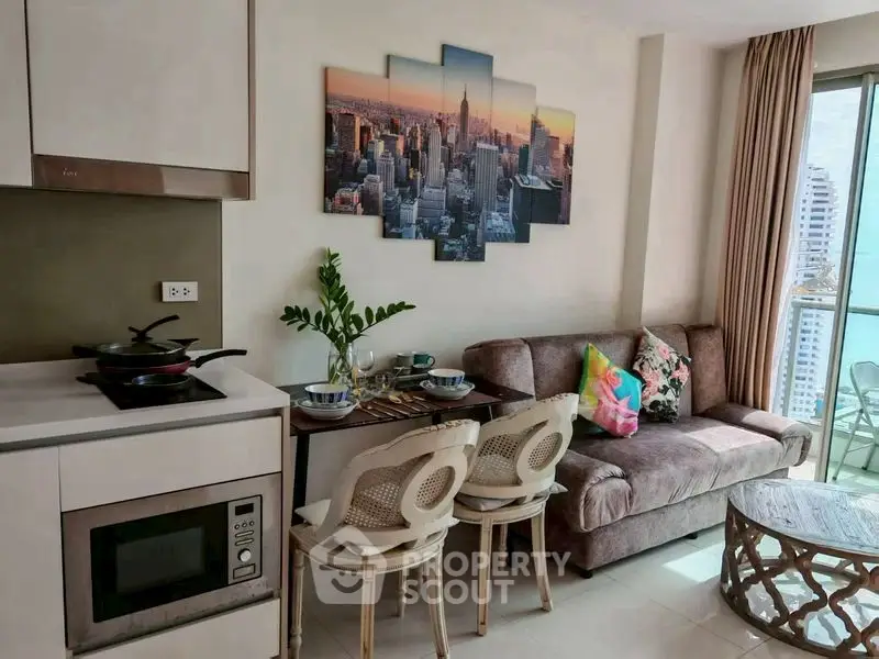 Chic modern living room with open kitchen and city view balcony.