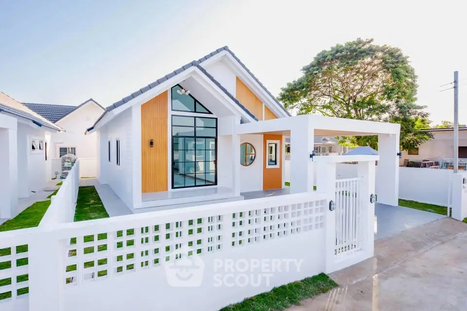 Modern white house with large windows and sleek design in a serene neighborhood.