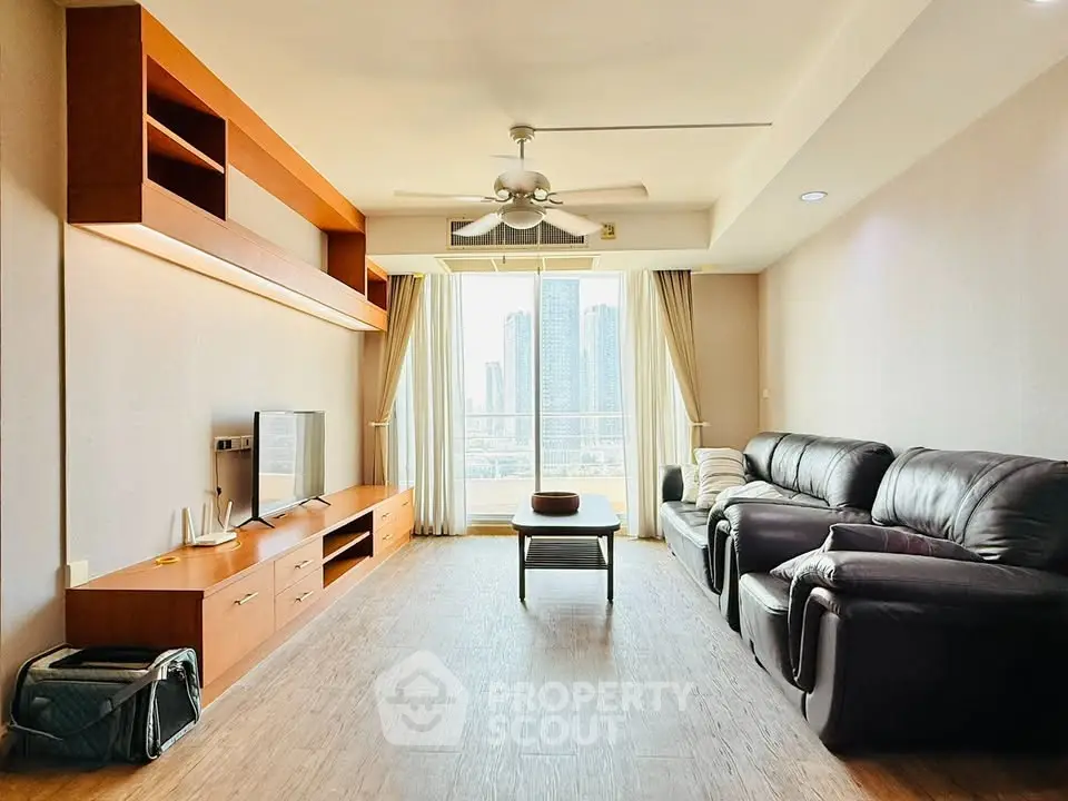 Spacious living room with modern furniture and city view, perfect for urban living.
