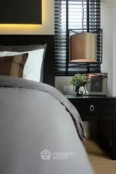 Luxurious bedroom with modern decor and ambient lighting, featuring a stylish bedside table and elegant window blinds.