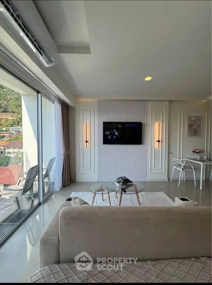 Luxurious living room with stunning view and modern decor, featuring large windows and elegant furnishings.