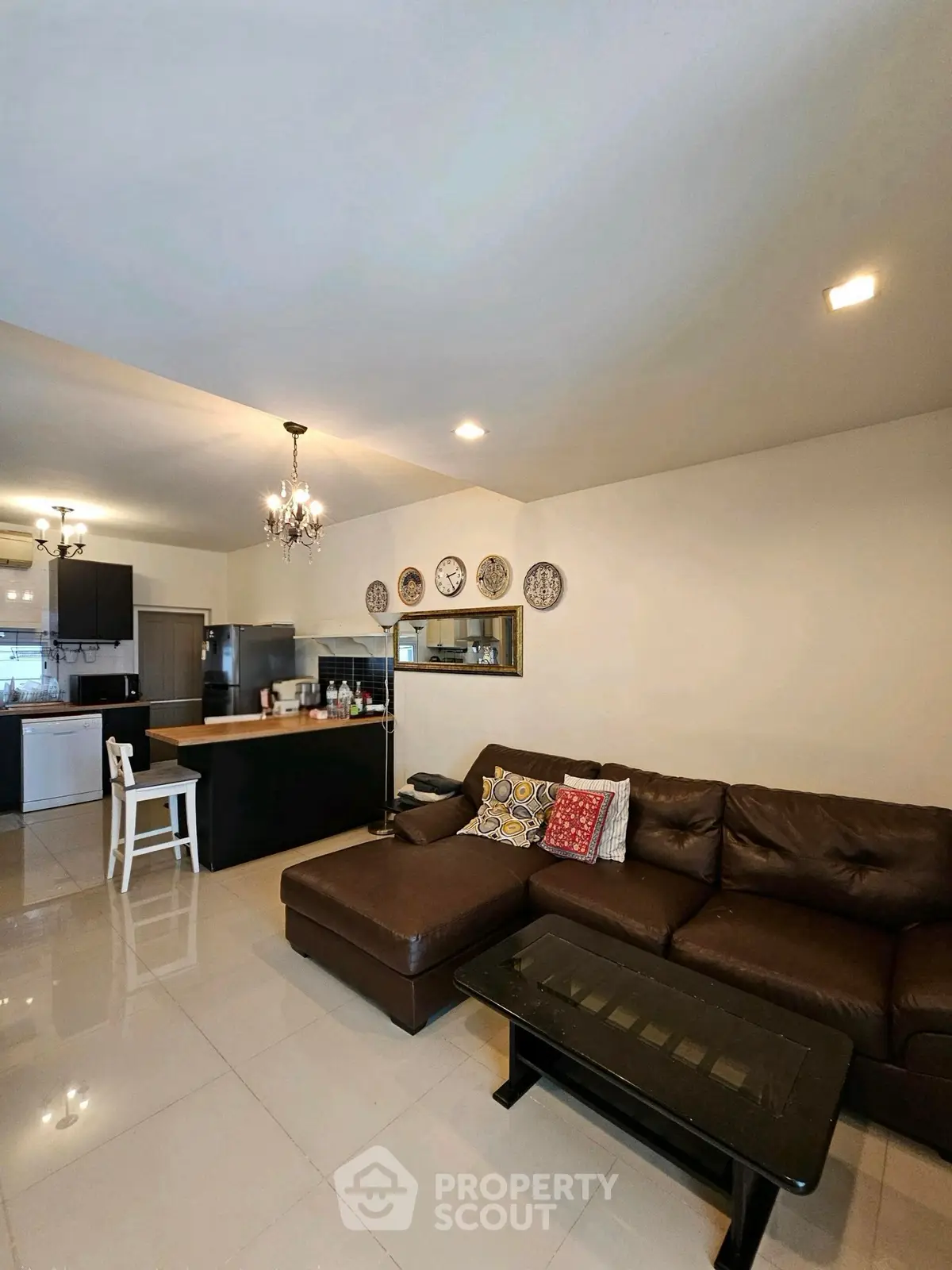 Spacious living room with modern kitchen and elegant decor in open layout apartment.