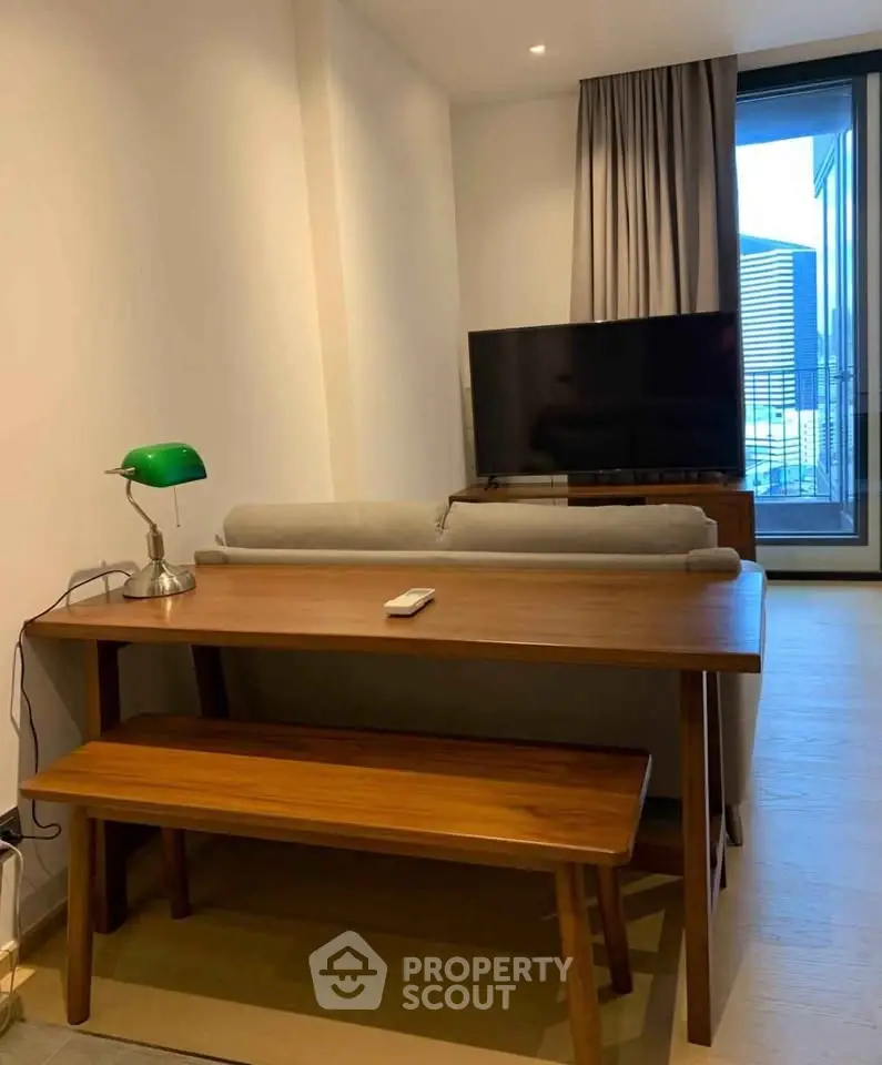 Modern living room with stylish wooden furniture and large TV, featuring a cozy ambiance and natural light.