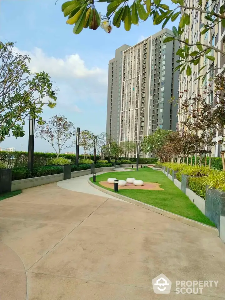 Modern high-rise building with landscaped garden and walking path