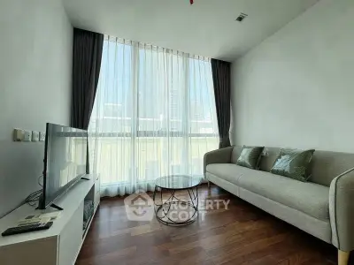 Modern living room with floor-to-ceiling windows and stylish furniture in a bright apartment.