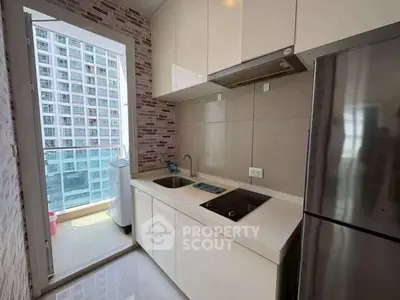 Modern kitchen with sleek cabinetry and balcony view in high-rise apartment