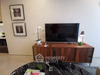 Modern living room with sleek TV stand, wall-mounted TV, and stylish decor.
