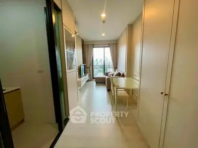 Modern apartment interior with open living and dining area, featuring a large window with city view.