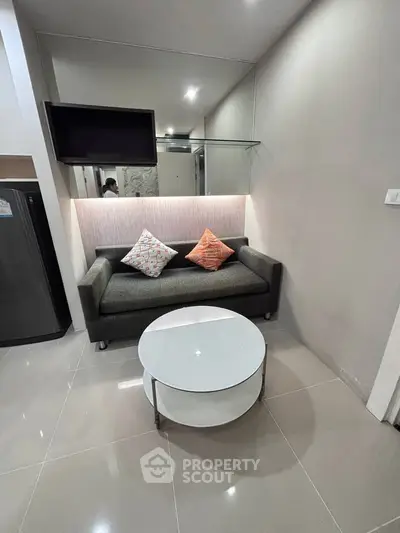 Modern living room with sleek sofa and stylish coffee table in a cozy apartment setting.