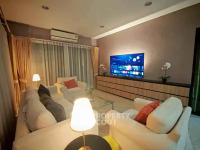 Elegant living room with modern decor and large TV, perfect for relaxation and entertainment.