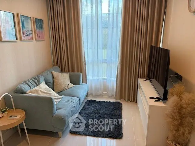 Cozy living room with plush sofa, stylish decor, and large window for natural light.