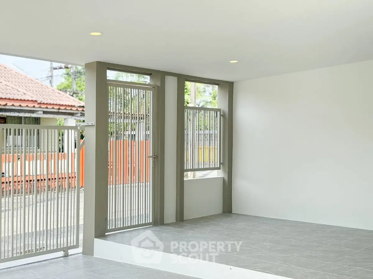 Modern minimalist entrance with sleek metal gate and tiled flooring