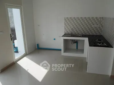 Modern minimalist kitchen with sleek countertops and ample natural light.