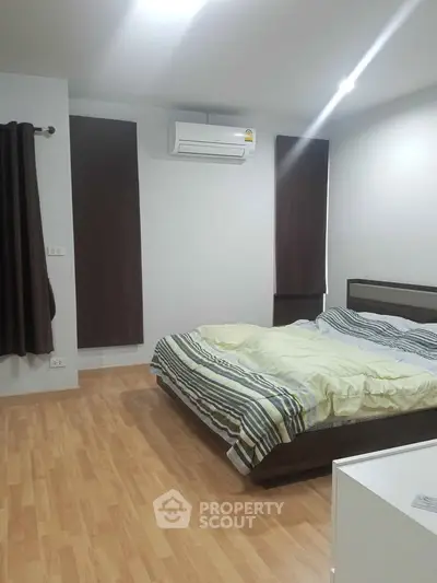 Spacious bedroom with modern decor and air conditioning in a stylish apartment.