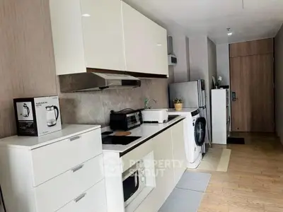 Modern kitchen with sleek appliances and stylish cabinetry in a compact layout.