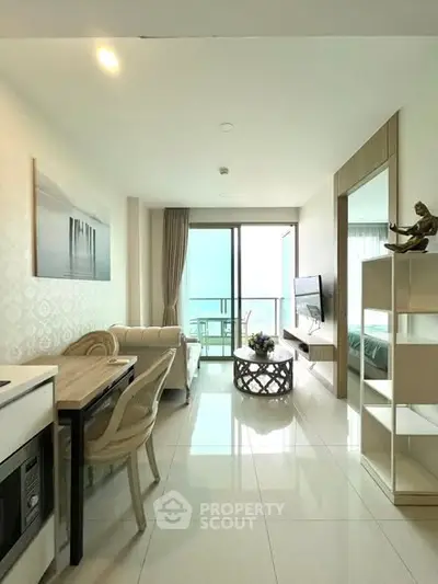 Modern living room with open layout and balcony view, featuring elegant decor and natural light.