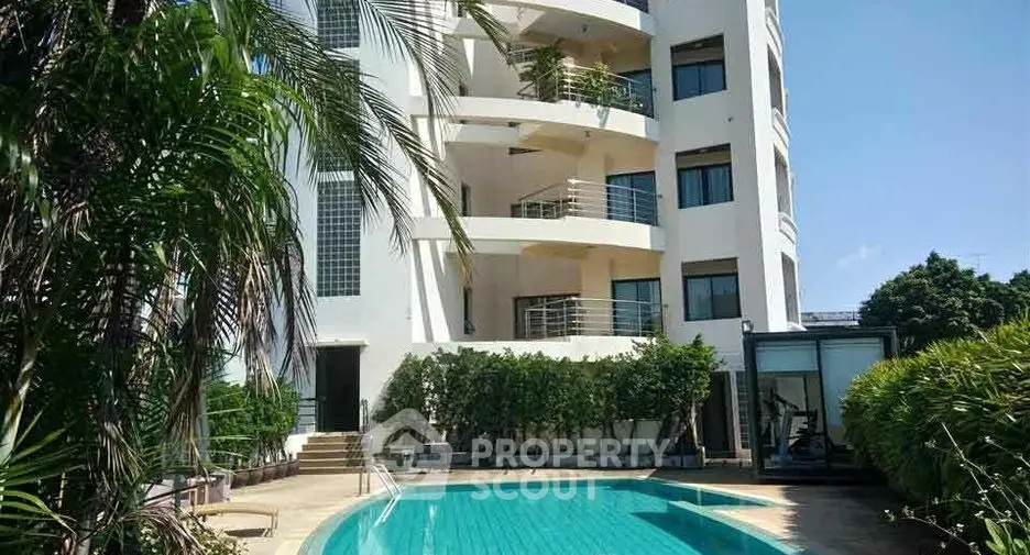Luxurious apartment building with pool and lush greenery