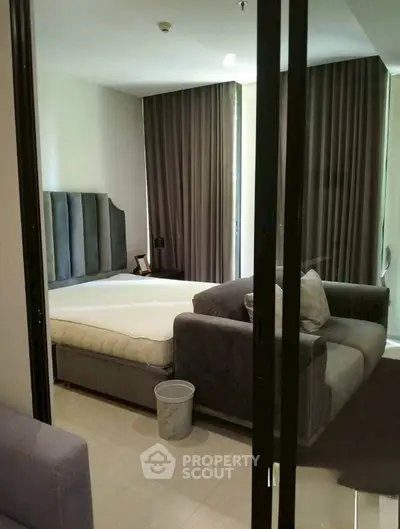 Modern bedroom with stylish decor and cozy seating area, perfect for relaxation.