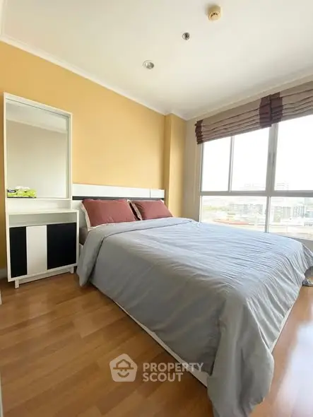 Spacious bedroom with large windows and modern decor in a high-rise apartment.