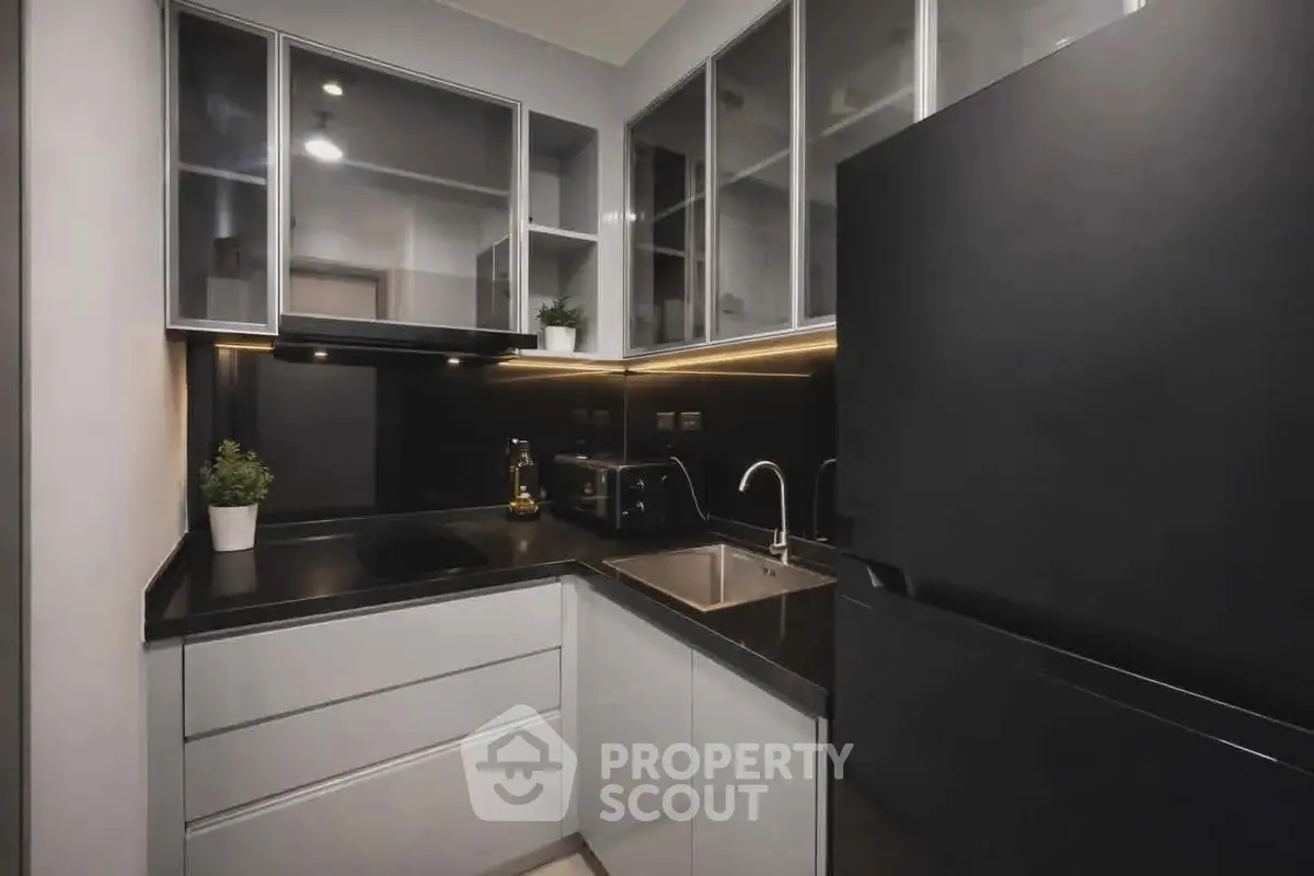 Modern kitchen with sleek black countertops and built-in appliances in a compact layout.