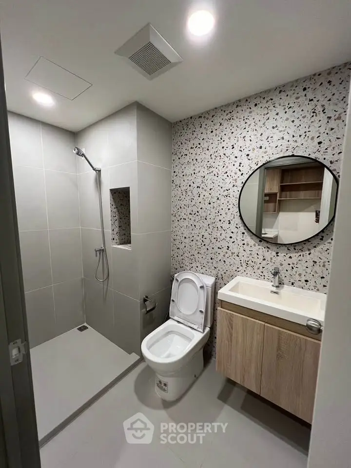 Modern bathroom with sleek shower and stylish vanity in contemporary apartment.