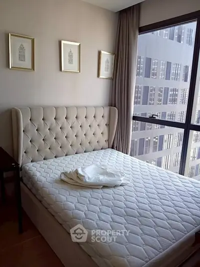 Modern bedroom with elegant tufted headboard and city view window