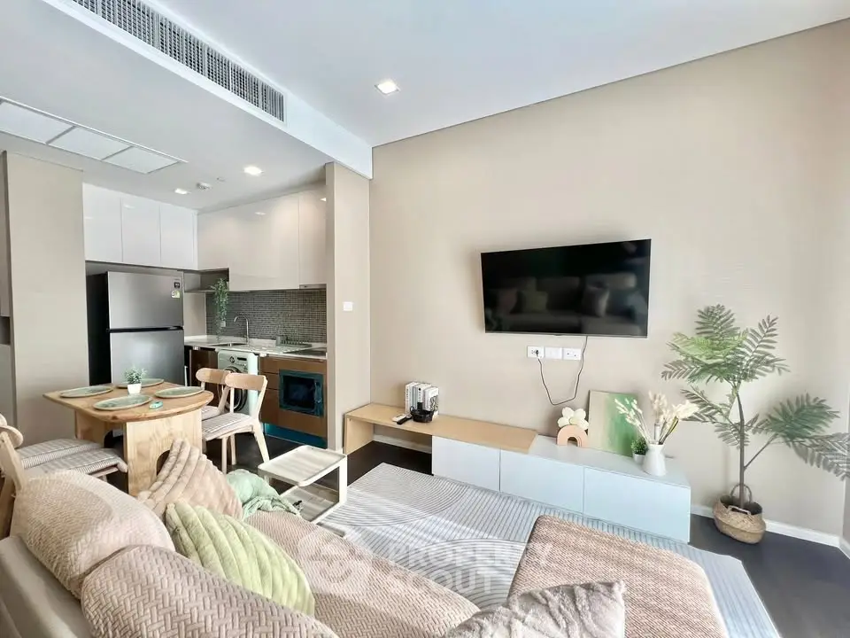 Modern living room with open kitchen, stylish decor, and cozy seating area in a contemporary apartment.