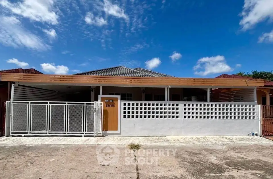 Charming single-story home with modern facade and spacious driveway under a clear blue sky.