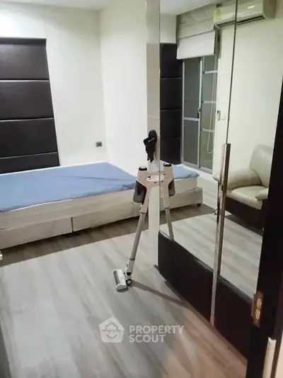 Modern bedroom with sleek flooring and exercise equipment, featuring a comfortable bed and stylish decor.