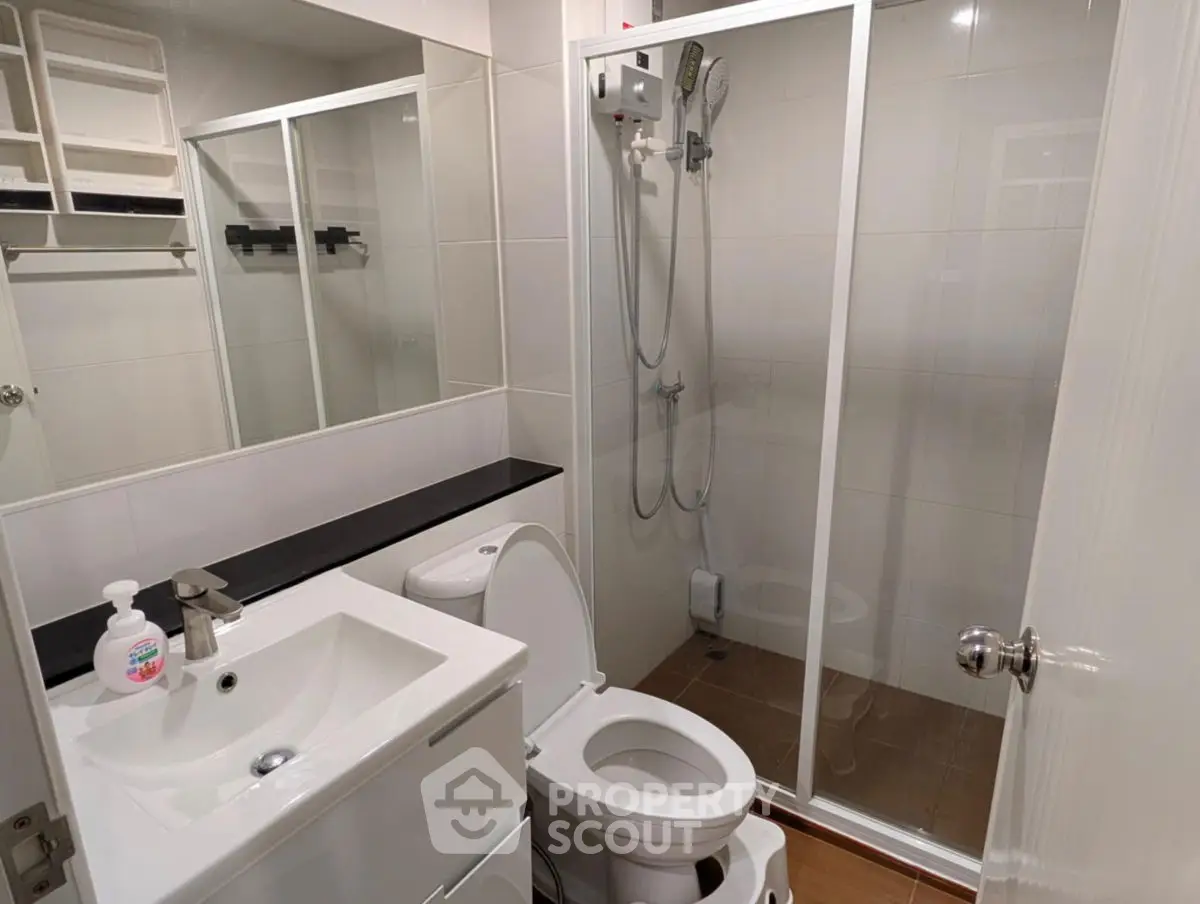 Modern bathroom with glass shower and sleek fixtures in a contemporary home.