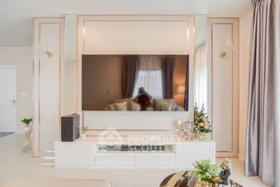 Elegant living room with modern decor and large wall-mounted TV, perfect for relaxation.