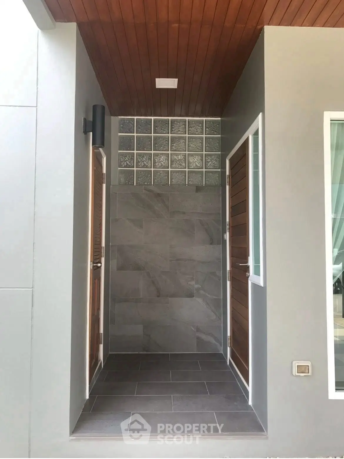 Modern entrance with sleek wooden doors and stylish tile flooring