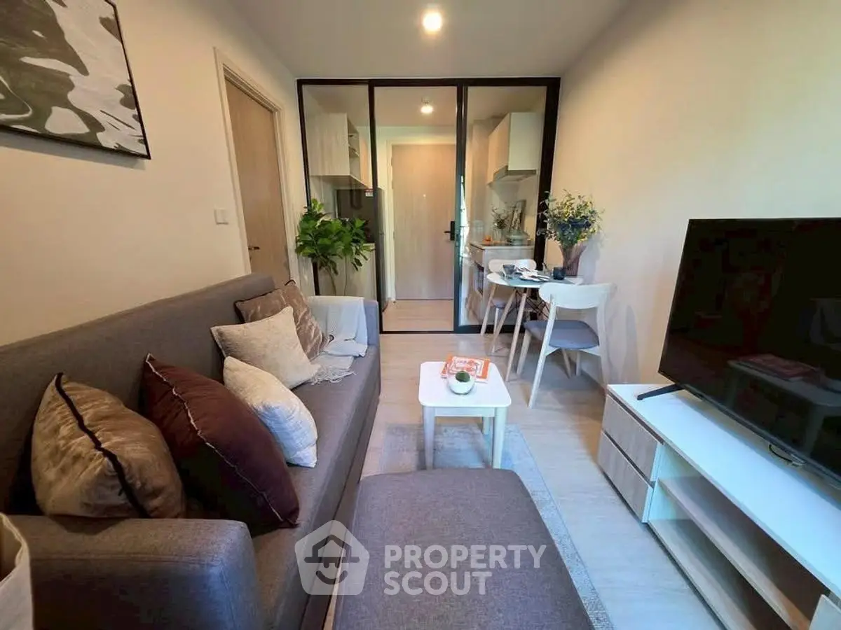 Modern living room with cozy seating and open kitchen layout in stylish apartment.