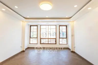 Spacious and bright living room with large windows and modern lighting