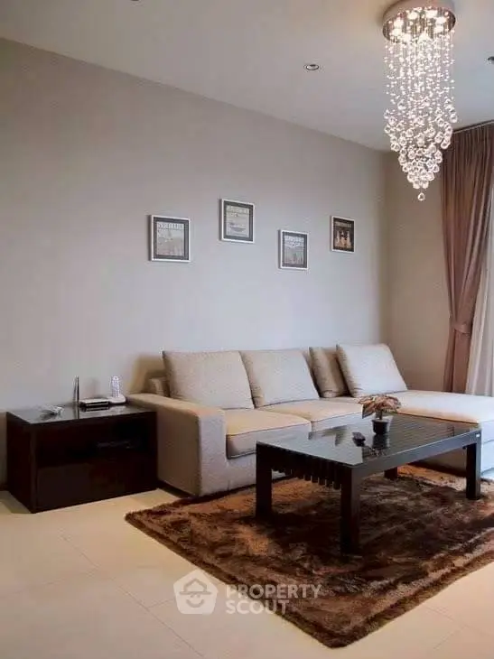 Elegant living room with plush sofa and chandelier in modern apartment.
