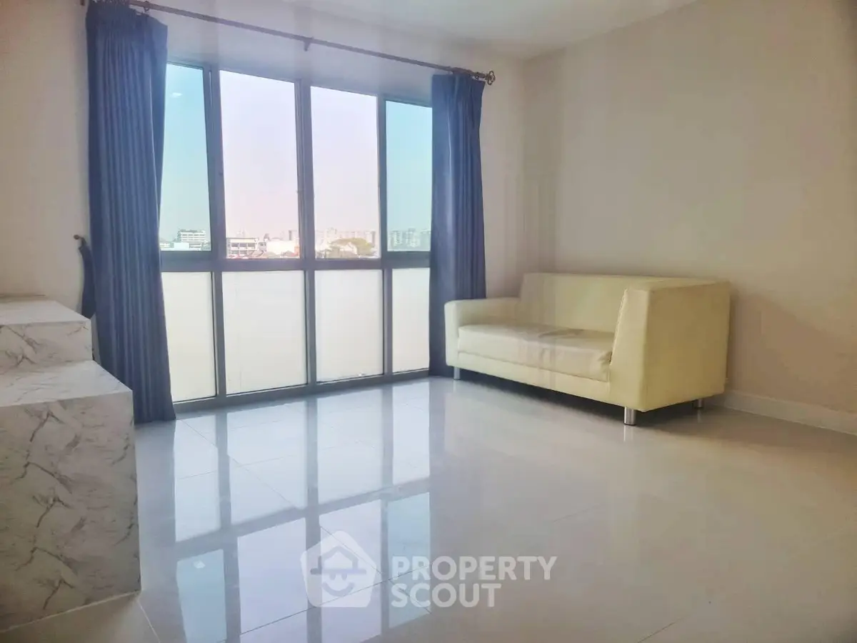 Bright living room with large window and modern sofa in a minimalist apartment.